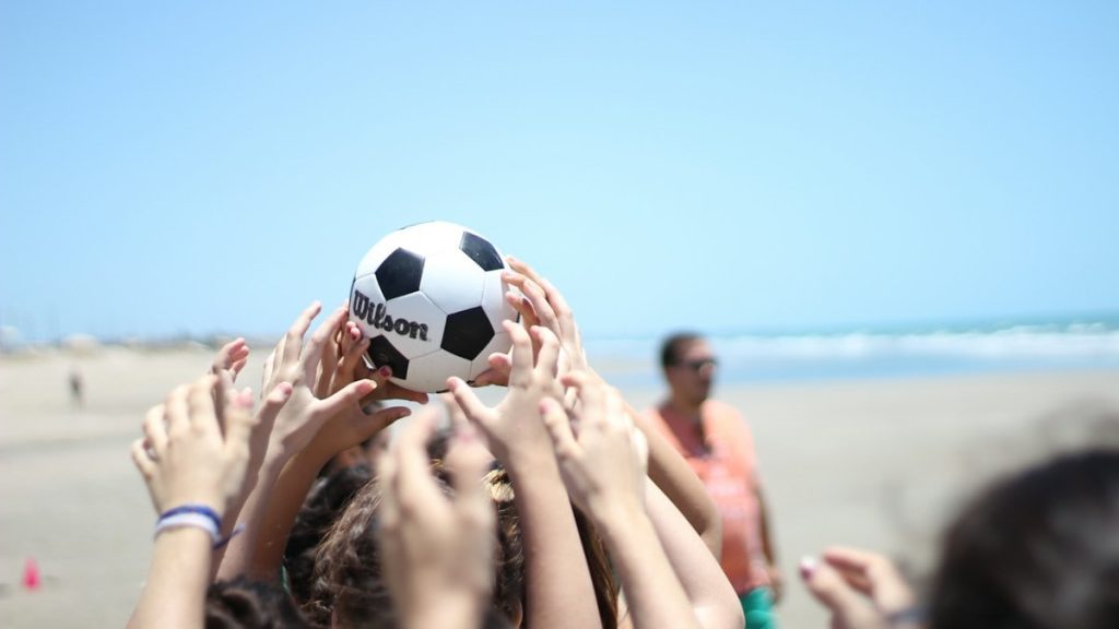 people holding white and black soccer ball under blue sky during daytime